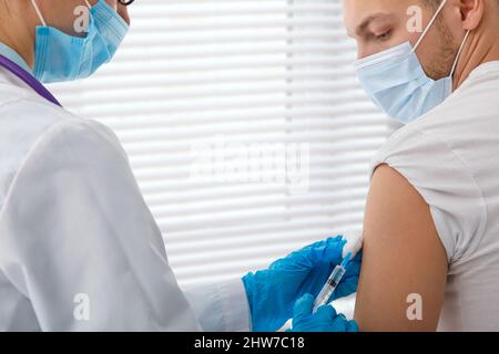 Le médecin tient une seringue avant de donner une injection à un patient dans un masque médical. Vaccin Covid-19 ou coronavirus. Vaccination de la population Banque D'Images