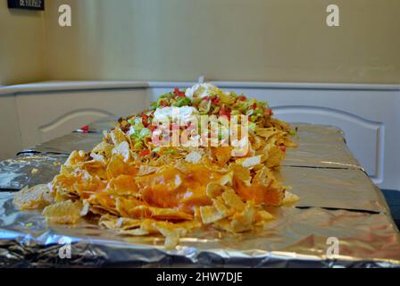 Table de cuisine Nacho table enveloppée de papier aluminium et couverte avec nachos Banque D'Images