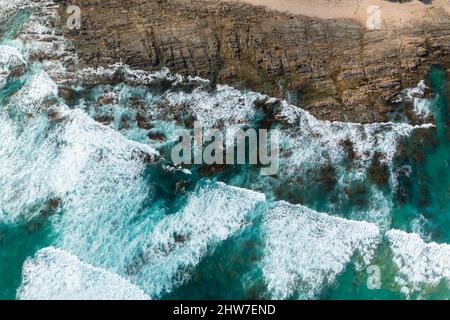 Vue aérienne de haut en bas des vagues de l'océan s'écrasant sur la rive rocheuse le long de la Great Ocean Road en Australie Banque D'Images