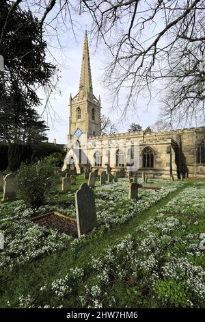 Snowdrop et Aconite fleurissent à l'église St Michael et All Angels, village d'Uffington, Lincolnshire, Angleterre, Royaume-Uni Banque D'Images