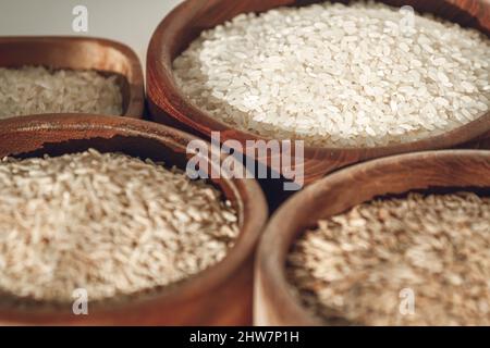 Ensemble de différents types de riz et de céréales dans des bols en bois Banque D'Images