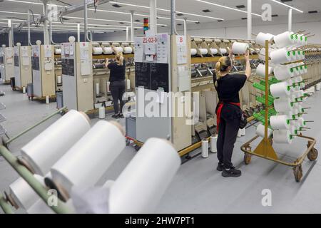 01 mars 2022, Saxe, Flöha: Des femmes travaillent dans l'usine de torsion d'OTEX Textilveredlung GmbH. La société, qui emploie 90 personnes, produit des fils spéciaux pour les produits médicaux et les textiles techniques. Lorsqu'un successeur de l'usine a été recherché en 2016, la société Thuringe Bauerfeind AG, fabricant d'aides médicales telles que des bandages, des orthèses ou des semelles intérieures orthopédiques, a simplement repris son fournisseur lui-même. Le nombre d'employés a augmenté, et maintenant plusieurs Roumains et Sud-Américains font également partie de la main-d'œuvre. Photo: Jan Woitas/dpa-Zentralbild/ZB Banque D'Images