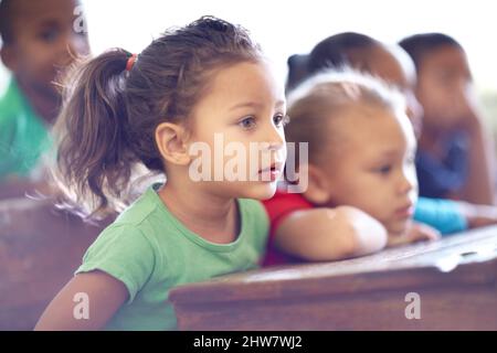 Des jeunes esprits enthousiastes au travail. De jolis petits enfants d'âge préscolaire assis ensemble dans une salle de classe. Banque D'Images