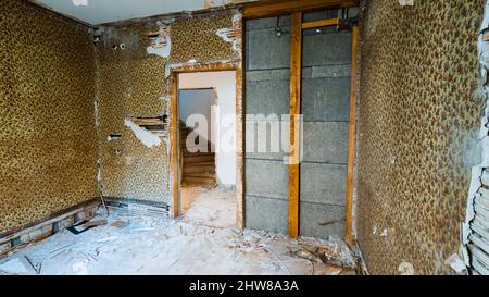 Ancienne maison abandonnée. La pièce est détruite, les murs sont cassés, les déchets sur le sol, le chaos. Banque D'Images