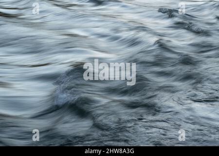 Écoulement rapide de l'eau dans les cours d'eau de montagne avec surface soyeuse et flou de mouvement - paysage abstrait gros plan Banque D'Images