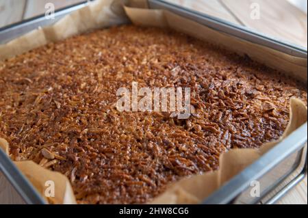 Gâteau aux amandes avec amandes caramélisées et rôties dans un moule à pain. Gros plan Banque D'Images