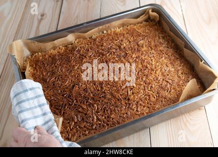 Gâteau aux amandes avec amandes caramélisées et rôties dans un moule à pain. Gros plan Banque D'Images