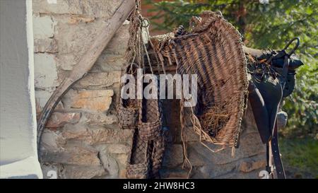 Concept rural rustique, anciennes chaussures russes artisanales de type Bast. Vidéo. Des paires de chaussures de baste accrochées sur le mur de la maison de brique ancienne, p à l'ancienne Banque D'Images