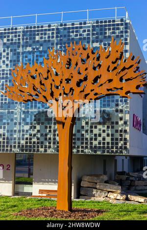 Arbre stylisé, évoquant un pin parapluie, en acier corten et jusqu'à 6 mètres de haut. Siège social du département de Herault 'Alco 2'. Oeuvre de l'artiste plastique Jordi. Montpellier, Occitanie, France Banque D'Images