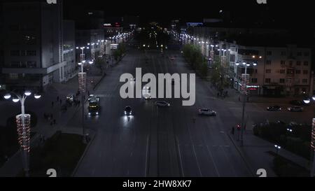 Vue aérienne de la circulation de nuit sur la route large le long de la grande rue de la ville. Belle avenue la nuit avec des voitures de voiture, des lanternes et des bâtiments historiques Banque D'Images