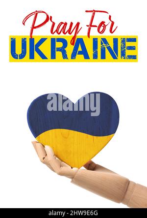 Main de mannequin avec coeur peint en couleurs de drapeau ukrainien sur fond blanc. Priez pour l'Ukraine Banque D'Images