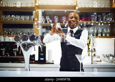 Il est temps de faire bouger les choses. Coupe courte d'un barman bien habillé debout derrière le comptoir. Banque D'Images