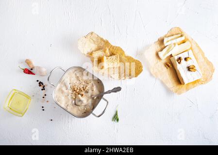 Faire fondre le cambre dans une casserole avec des champignons, du basilic et des croûtons à l'ail, sur une table en bois de style rustique Banque D'Images