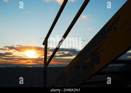 Le soleil se lève derrière l'escalier d'une hutte de sauveteurs sur South Beach, Miami Beach Banque D'Images