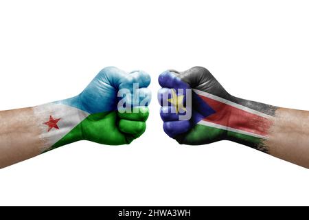 Deux mains poinçonner l'une à l'autre sur fond blanc. Drapeaux de pays peint les poings, le concept de crise de conflit entre djibouti et le sud du soudan Banque D'Images