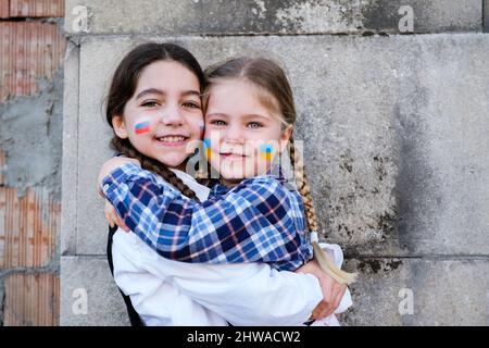 Portrait de deux petites filles qui embrassent le visage avec des drapeaux russes et ukrainiens. Concept de paix, mettre fin à la guerre et à l'amitié des enfants Banque D'Images