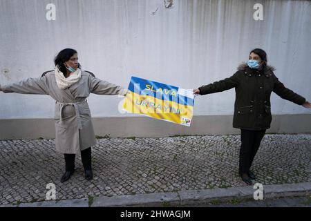 Lisbonne, Portugal. 04th mars 2022. Deux militants manifestent un signe en faveur du peuple ukrainien lors d'un rassemblement contre l'invasion russe. L'événement a été organisé par l'Association des Ukrainiens au Portugal devant l'ambassade du gouvernement chinois. Au cours de l'action, des messages ont été affichés appelant les gouvernements à se tenir fermement contre l'agression contre l'Ukraine. Cette manifestation vise également à montrer la solidarité de la communauté portugaise et ukrainienne vivant dans le pays. (Photo de Jorge Castellanos/SOPA Images/Sipa USA) crédit: SIPA USA/Alay Live News Banque D'Images
