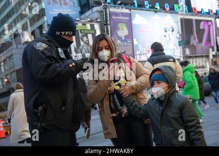 New York, États-Unis. 05th mars 2022. (220305) -- NEW YORK, le 5 mars 2022 (Xinhua) -- Une femme s'entretient avec un policier sur Times Square à New York, aux États-Unis, le 4 mars 2022. La ville de New York suspendra le programme de passeport du vaccin COVID-19 et supprimera le mandat de masque intérieur dans les écoles publiques pour les étudiants K-12 à partir de lundi prochain, a déclaré le maire de la ville de New York, Eric Adams, lors d'un point de presse, vendredi. La décision est fondée sur une forte baisse des nouveaux cas de COVID-19 et des hospitalisations, ainsi que sur 96 pour cent du taux de vaccination chez les adultes dans la ville. (Michael Appleton/Mayoral Photography Office/Handou Banque D'Images