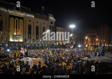 Tbilissi, Géorgie. 04th mars 2022. Une foule de gens attend le discours en direct de l'ukrainien, le président Volodymyr Zelenskyy. Trente mille personnes se sont rassemblées devant le bâtiment du Parlement de Tbilissi pour écouter le discours en direct du président de l'Ukraine où il déclare que « l'Ukraine ne donnera jamais son territoire à la Russie et l'Ukraine se battra contre les Russes pour gagner cette guerre. Vous êtes tous des Ukrainiens aujourd'hui". Crédit : SOPA Images Limited/Alamy Live News Banque D'Images