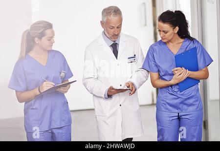 En leur montrant les cordes. Plan de culture d'un médecin mature enseignant deux femmes internes dans le couloir de l'hôpital. Banque D'Images