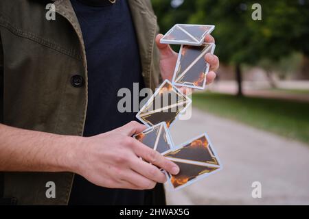 Détail des mains d'un magicien de rue qui agitant les cartes dans la rue Banque D'Images