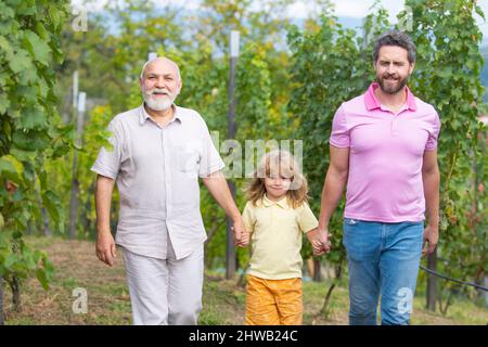 Famille de génération masculine marchant avec trois générations différentes âges grand-père père et fils dans le jardin d'été. Banque D'Images