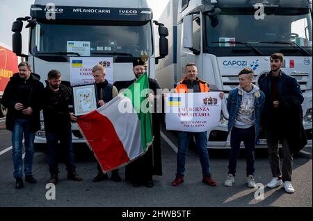 Milan, Italie. 04th mars 2022. Les camionneurs vus avec l'archevêque Avondios Bica, portant un drapeau italien, l'icône de la Vierge Marie et l'écriteau « urgence humanitaire ». Près de 15 véhicules, transportant des aides humanitaires, organisés par l'église orthodoxe de San Nicola et Ambrogio al Lazzaretto à Milan, partent le 4th mars pour apporter des vêtements, de la nourriture et des nécessités à des personnes en Ukraine, traversant la Roumanie. L'archevêque Avondios Bica dirige le convoi jusqu'à Chernivtsi, en Ukraine. (Photo de Valeria Ferraro/SOPA Images/Sipa USA) crédit: SIPA USA/Alay Live News Banque D'Images