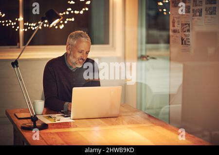 HES n'a jamais peur du travail. Photo courte d'un homme d'affaires mature travaillant tard au bureau. Banque D'Images