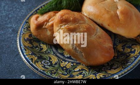 Patties ukrainiennes (Pasties, gâteaux chauds, Pirozhki, tartes) sur une assiette. Tartes maison traditionnelles à la viande Banque D'Images