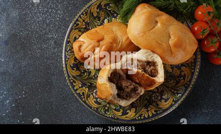 Patties ukrainiennes (Pasties, gâteaux chauds, Pirozhki, tartes) sur une assiette. Tartes maison traditionnelles à la viande Banque D'Images