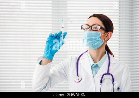 Une infirmière tient une seringue avant de procéder à une injection. Le concept de vaccination. Banque D'Images