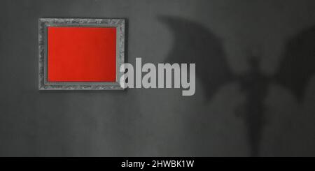 Ombre du diable sur un mur sombre, fond rouge à l'intérieur d'un cadre en bois, atmosphère mystique Banque D'Images