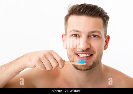 Le sourire d'un jeune homme en gros plan. Un homme tient une brosse à dents dans la main. Le concept de soins buccaux. Banque D'Images