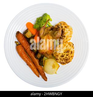 Vue de dessus de la caille grillé servi sur plaque blanche avec des légumes cuits en sauce moutarde-miel. Plus isolé sur fond blanc Banque D'Images