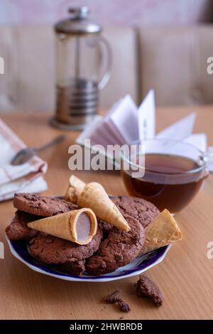 Thé avec biscuits et gaufres, un livre ouvert sur la table à l'intérieur de la chambre Banque D'Images