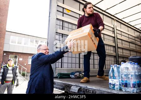 Hanovre, Allemagne. 05th mars 2022. Stephan Weil (l, SPD), ministre-président de la Basse-Saxe, remet une boîte de fournitures d'aide à un assistant au point de collecte pour des dons en nature de l'« Association ukrainienne de Basse-Saxe ». Credit: Moritz Frankenberg/dpa/Alay Live News Banque D'Images