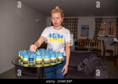 Windsor, Royaume-Uni. 5th mars 2022. Olga Line, âgée de 35 ans et née en Ukraine, qui vit à Windsor, dans le Berkshire, avec son mari Roger, fait des bougies de la flamme de la liberté aux couleurs du drapeau ukrainien pour recueillir des fonds urgents pour l'aide humanitaire aux Ukrainiens. Les parents et la famille d'Olga vivent à Kiev et ne peuvent pas partir maintenant car c'est trop dangereux. Les réserves d'eau et de nourriture sont faibles. Olga est déterminée à faire tout son possible pour aider les Ukrainiens bloqués. Les bougies sont en vente via William West bougies et ne sont pas à but lucratif. Crédit : Maureen McLean/Alay Live News Banque D'Images