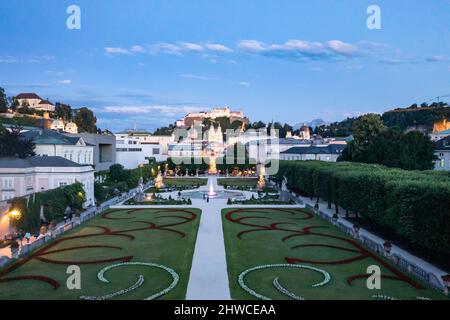 Vue classique des célèbres jardins Mirabell avec la forteresse historique de Hohensalzburg en arrière-plan dans la soirée à Salzbourg, Autriche. Banque D'Images