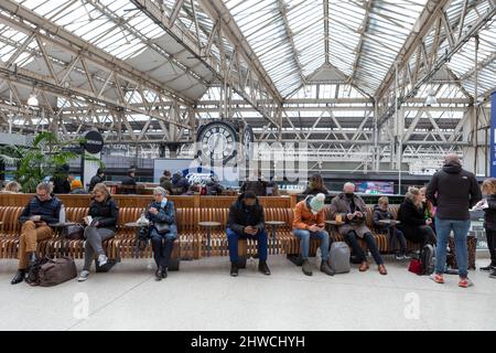 Passagers vus assis à la gare de Waterloo après l'annonce de l'arrêt des trains. La tempête Eunice a frappé Londres vers midi, causant mil Banque D'Images