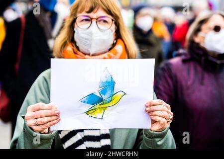 Hanovre, Allemagne. 05th mars 2022. L'image d'une colombe de paix aux couleurs nationales ukrainiennes peut être vue sur l'affiche d'un manifestant lors d'une manifestation à Ernst-August-Platz contre l'attaque de la Russie contre l'Ukraine. Credit: Moritz Frankenberg/dpa/Alay Live News Banque D'Images