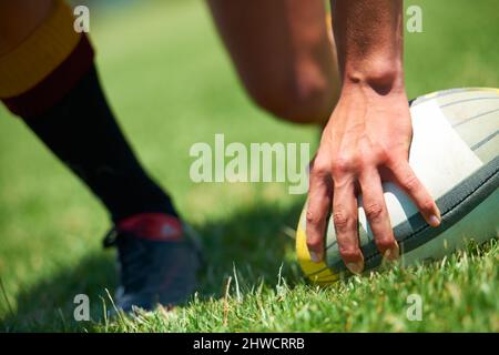 Nous sommes arrivés à la victoire. Gros plan d'une main de homme sur un ballon de rugby. Banque D'Images