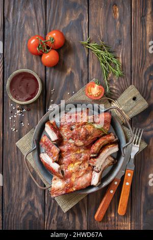 Barbecue de viande de veau grillée sur une petite côte de rechange sur une table en bois rustique. Vue de dessus, plan d'appartement. Banque D'Images