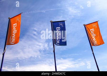 Drapeaux orange et bleu à l'extérieur d'un développement Bellway Homes, maisons neuves constructeurs. Banque D'Images