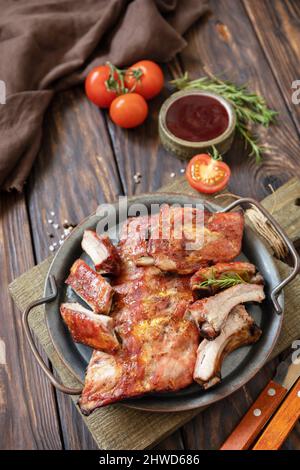 Barbecue de viande de veau grillée sur une petite côte de rechange sur une table en bois rustique. Banque D'Images