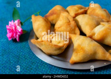 Image floue de Samosa, samsa ou smosa maison. Une cuisine traditionnelle indienne épicée végétarienne. Plat Iftaari, mise au point sélective. Banque D'Images