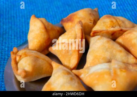 Image floue de Samosa, samsa ou smosa maison. Une cuisine traditionnelle indienne épicée végétarienne. Plat Iftaari, mise au point sélective. Banque D'Images