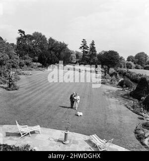 Johnnie et Fanny Cradock, l'expert en cuisine télévisuelle, ont déménagé dans une nouvelle maison près de Watford, dans le Hertfordshire. La maison elle-même était à l'origine un chalet de 18th siècle qui au fil des ans a été construit sur, en maintenant le plus près possible de la façade d'origine. L'intérieur a été complètement fait par les Cradock's avec tous les inconvénients modernes habituels, y compris une grande cuisine contenant six poêles à gaz., dans laquelle ils instruire une petite équipe de jeunes qui les aident dans leurs émissions de télévision. Johnnie et Fanny dans le jardin. 9th juin 1969. Banque D'Images