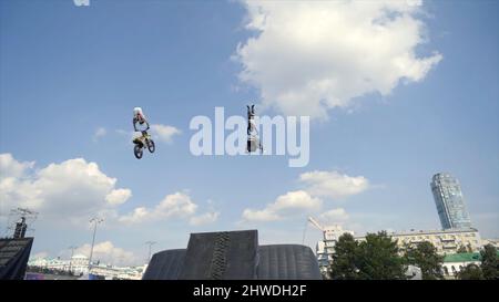 Le motocycliste réalise des cascades avec le saut dans le festival moto. Action. Performance en moto et motoneige au printemps du festival moto. Banque D'Images