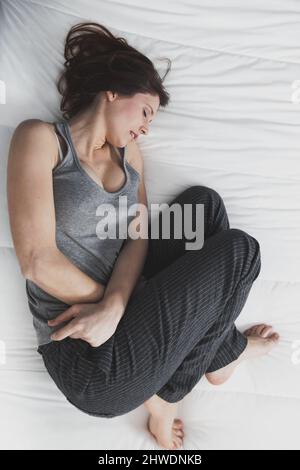 Portrait d'une jeune femme en douleur avec PMS, syndrome prémenstural Banque D'Images