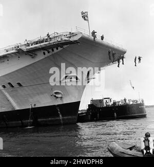 Vingt plongeurs de navires de H.M.S. Hermes s'est joint à Janet Abercombie, âgée de 14 ans, championne de plongée anglaise et galloise, faisant une plongée de 45 pieds dans le port de Portsmouth depuis le pont supérieur de H.M.S. Hermes. Tout cela a été en faveur de plans promotionnels pour une édition spéciale de Thames Television 'Opportunity Knocks' devant être projeté le 10th novembre. Janet Abercombie dirige les plongeurs lorsqu'elle plonge dans l'eau. 3rd novembre 1969. Banque D'Images